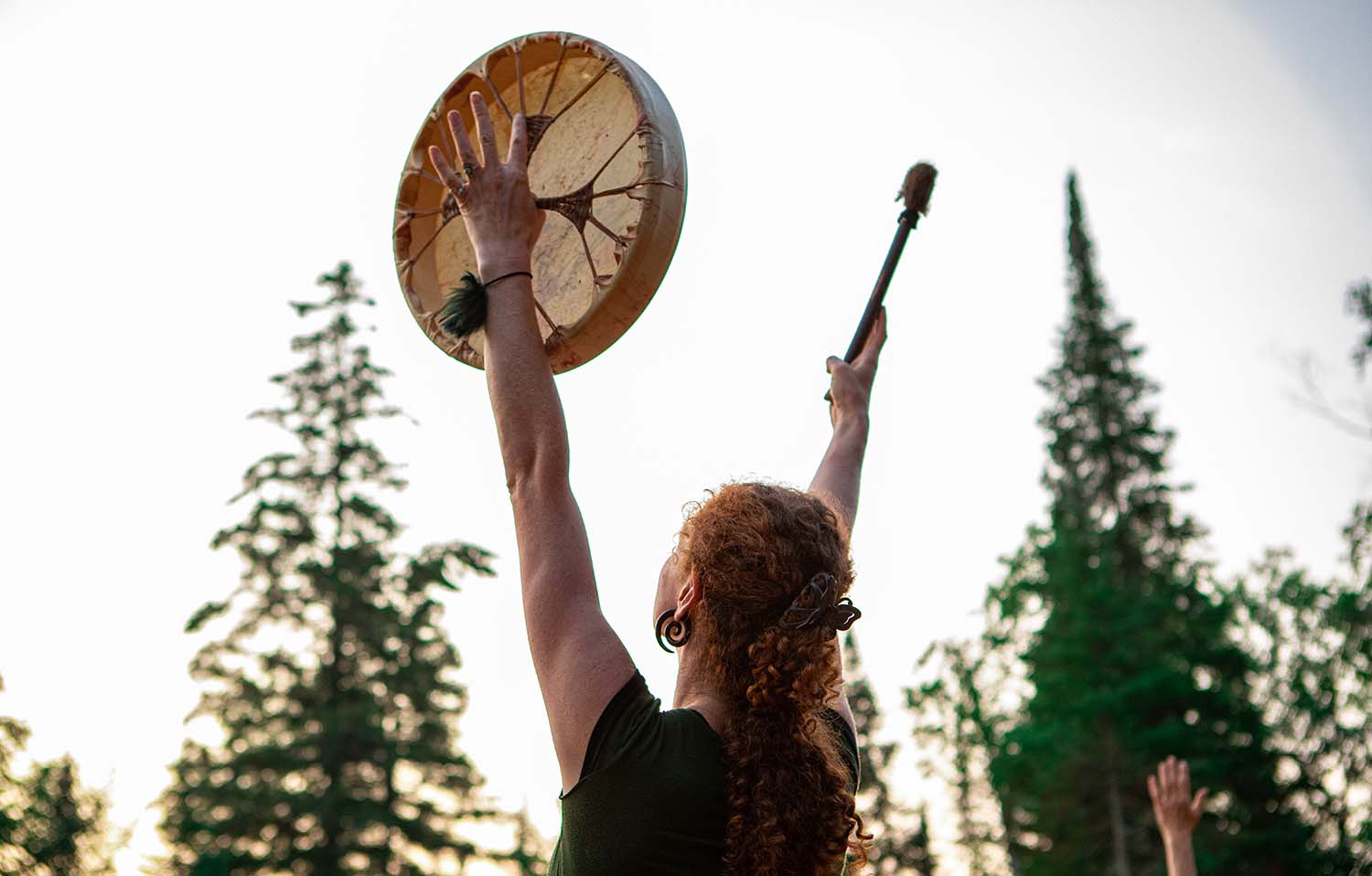 woman holding sacred drum in the sky