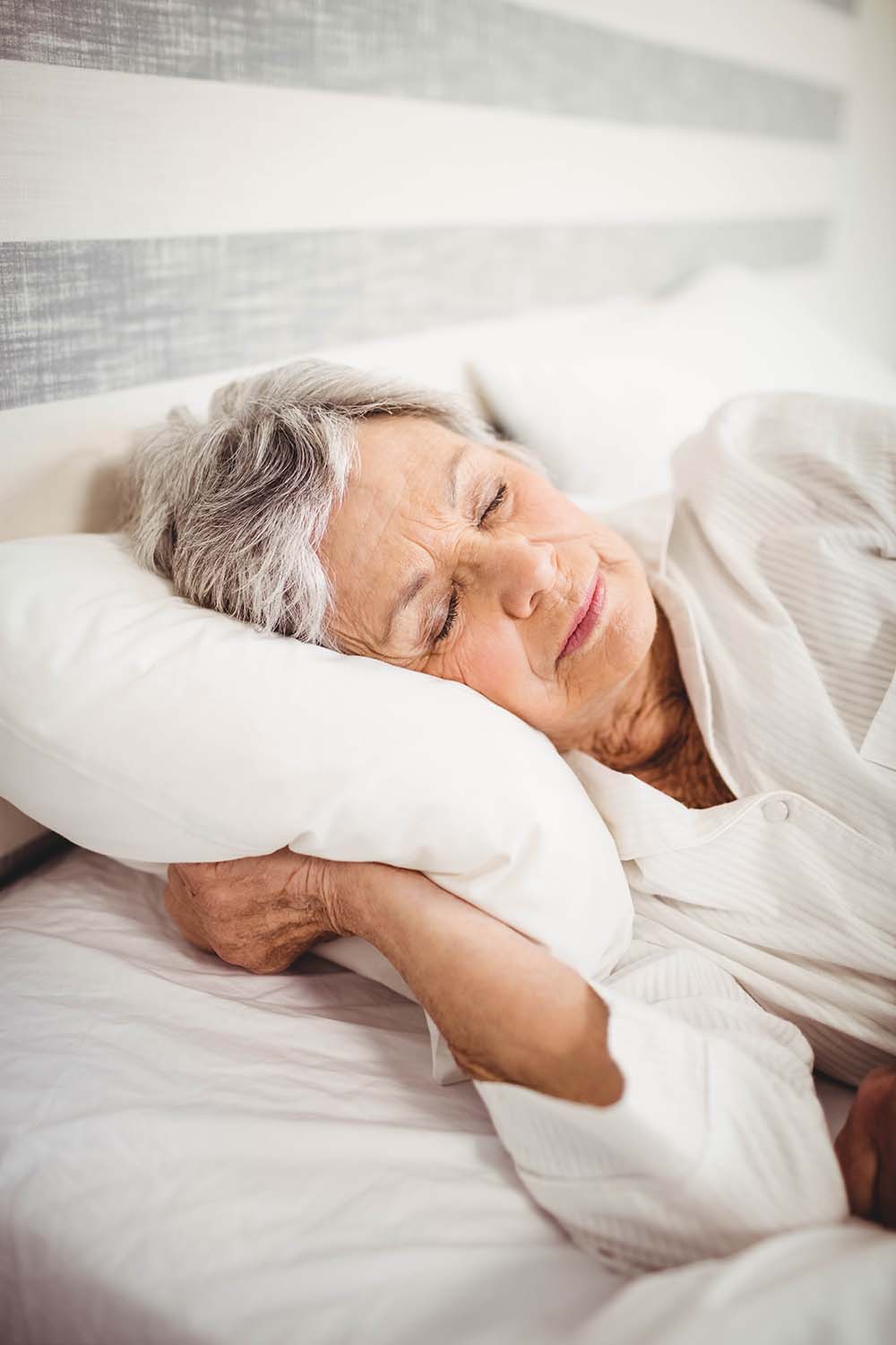 Senior woman sleeping on bed